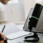 person holding black and green portable speaker