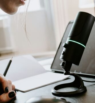 person holding black and green portable speaker